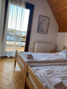 una camera da letto con un letto e una grande finestra di Kuća sa pogledom na Tornik a Zlatibor