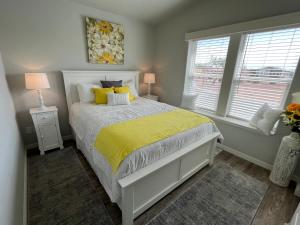 a bedroom with a bed with yellow sheets and two windows at Monte Vista Village Resort Mesa 3 Bed 2 Bath Age 55 Plus Community in Mesa +44 photos