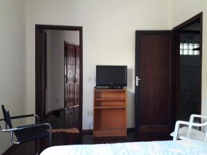 um quarto com uma cama e uma televisão numa cómoda em Serra Negra Apartment em Serra Negra
