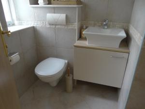 uma casa de banho com um WC branco e um lavatório. em Rooms Stella em Split
