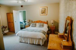 a bedroom with a bed and a table and a mirror at Toghill House Farm in Wick