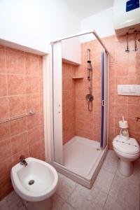 uma casa de banho com um chuveiro, um WC e um lavatório. em Pensione La Torretta em Peschici