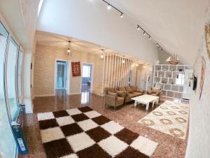 ein großes Wohnzimmer mit einem karierten Boden in der Unterkunft Caspian Villa Merdekan in Şüvǝlǝn