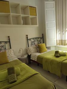 格拉納達的住宿－Principe A，一间卧室配有两张带绿床单的床