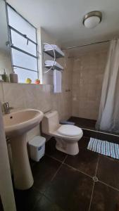 Un baño con un inodoro blanco y un lavabo. en Departamento INCA PALACE EXPERIENCE, en Puno 3 fotos más