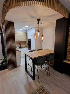 uma cozinha e sala de jantar com uma mesa de madeira e cadeiras em Mountain Wings Bjelasnica Apartment em Bjelašnica