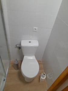 - une salle de bains avec des toilettes blanches dans une cabine dans l'établissement Habitación rústica independiente con todas las comodidades y sofacama, à Tordesillas