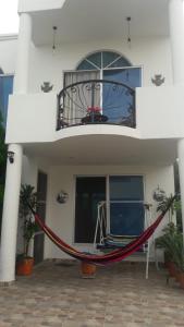 a house with a hammock in front of a balcony at Casa Veraneo Flandes con Piscina Privada in Flandes