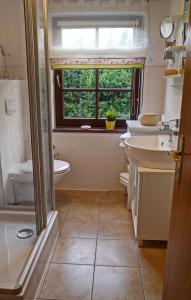 łazienka z umywalką, toaletą i oknem w obiekcie Haus Sonnenschein w Zingst