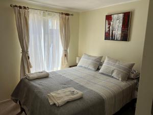 1 dormitorio con 1 cama con 2 toallas en Apart hotel Chillan - Full house - Ohiggins - Empresas- Factura - Parking en Chillán