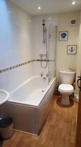 ein Badezimmer mit einer weißen Badewanne und einem WC in der Unterkunft Watchet Cottage in Watchet