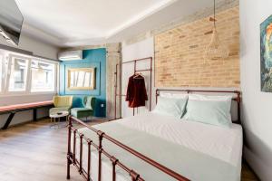 a bedroom with a bed and a brick wall at Na'maste Apartments in Athens