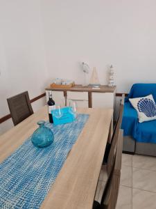 a dining room table with a blue vase on a blue rug at Quarteira T1 - Oceanides in Quarteira