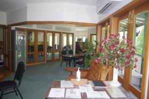 a dining room with a table with flowers on it at The Grand Halls Gap in Halls Gap