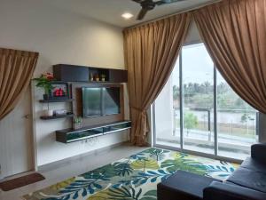 a living room with a tv and a large window at D'Corner Homestay Kluang Perdana in Kluang