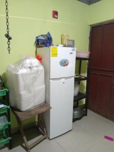 una nevera blanca en una cocina con estantería en Hostal Brisas Calobrenas, en Calobre