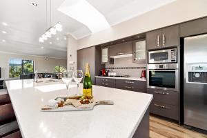a kitchen with a white counter with a bottle of wine at The Grand @ Taupo in Taupo