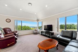 陶波的住宿－The Grand @ Taupo，客厅配有沙发和桌子