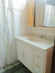 y baño con lavabo y espejo. en Alojamiento Santino, en Cataratas del Iguazu en Puerto Iguazú