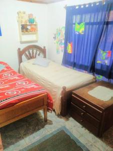 1 dormitorio con 2 camas individuales y mesa en Alojamiento Santino, en Cataratas del Iguazu en Puerto Iguazú