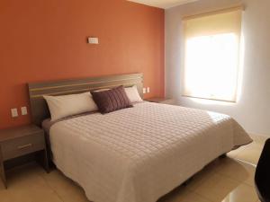 a bedroom with a large bed with a window at H Rooms Hoteles Inn in La Piedad Cavadas