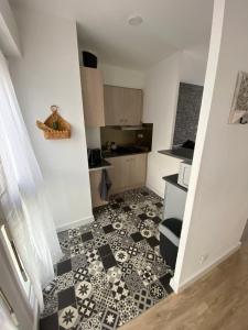 a small kitchen with a black and white tile floor at Appartement au centre historique de Nîmes in Nîmes