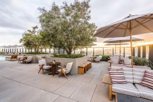 a patio with tables and chairs and an umbrella at Sky Rise Apartments in Los Angeles