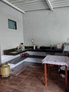 a kitchen with a counter and a table in a room at Suítes Ponta do Sol (Trator) in Capitólio