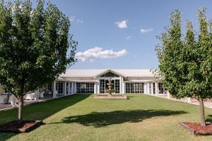 a building with a fountain in the middle of a yard at Leogate Estate Villas in Pokolbin