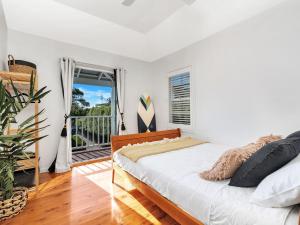 a bedroom with a bed and a balcony at The Green Whaler Hyams Beach in Hyams Beach