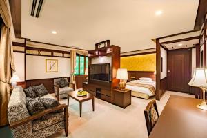 a hotel room with a couch and a bed at Kanazawa Hakuchoro Hotel Sanraku -Natural Hot Spring- in Kanazawa