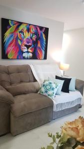 a painting of a lion on a wall above a couch at Apartamento CONFORTO prox do SHOPPING NAÇÕES prox ABBA Church - cozinha completa - Ar condicionado - WiFi - Smart Tv 32' - Youtube e Apps - estacionamento privado - Portaria 24h - Acomoda até 8 pessoas - Anfitriã SuperHost no BNB 5 Estrelas in Criciúma