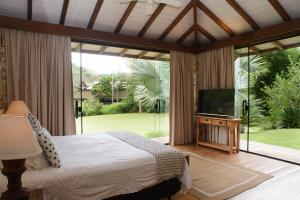 a bedroom with a bed and a flat screen tv at Pousada Boutique Itaipava in Itaipava