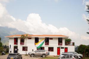 Un edificio blanco con coches aparcados delante. en El Edén hotel Campestre, en Pensilvania
