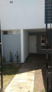 an empty garage with a white wall and a door at Casa Neblina confort y tranquilidad. in León