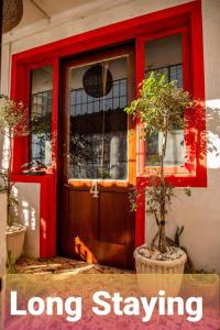 a dog laying in front of a red door at Guesthouse MALAGUETA INN I & II in Maputo