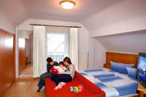 a family sitting on a bed in a bedroom at Alpenchalet Mitterlechner in Bad Hofgastein