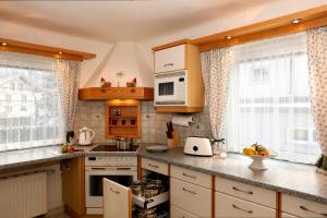 cocina con armarios blancos y encimera en Alpenchalet Mitterlechner, en Bad Hofgastein