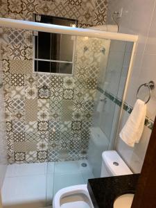 a bathroom with a shower and a toilet and a sink at Casa Aconchegante próximo da balsa in Ilhabela
