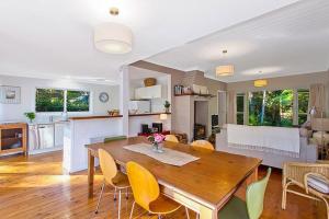 a dining room and living room with a table and chairs at Wildwood - Pearl Beach in Pearl Beach