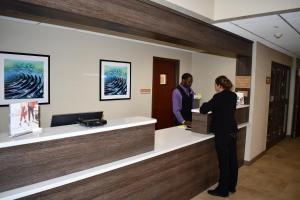 a man and a woman standing at a reception desk at Candlewood Suites Grand Rapids Airport by IHG in Grand Rapids