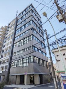 a tall gray building with a lot of windows at PRISM INN OGU in Tokyo