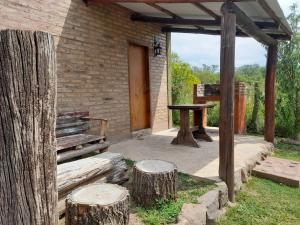 un patio con una mesa de madera y 2 troncos en EL ZORZAL Dormis con Galeria en Villa del Dique