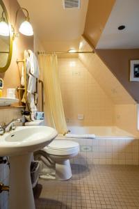 a bathroom with a sink and a toilet and a tub at Saddleback Inn at Lake Arrowhead in Lake Arrowhead