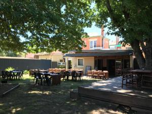 a group of tables and chairs under a tree at Myrtleford Hotel in Myrtleford