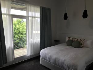 um quarto com uma cama e uma porta de vidro deslizante em Myrtleford Hotel em Myrtleford