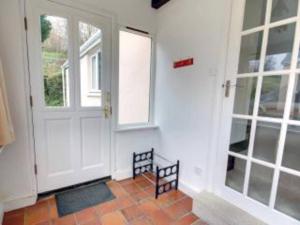 a hallway with a white door and a window at Priory Cottage, North Devon in Barnstaple