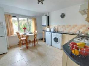 a kitchen with a table and a counter top at Priory Cottage, North Devon in Barnstaple