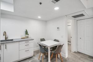 a white kitchen with a white table and chairs at Condo close to Strip and Raiders Stadium in Las Vegas