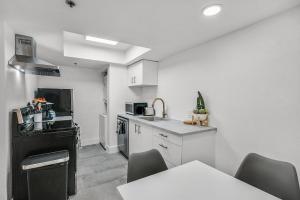 a white kitchen with a sink and a table at Condo close to Strip and Raiders Stadium in Las Vegas